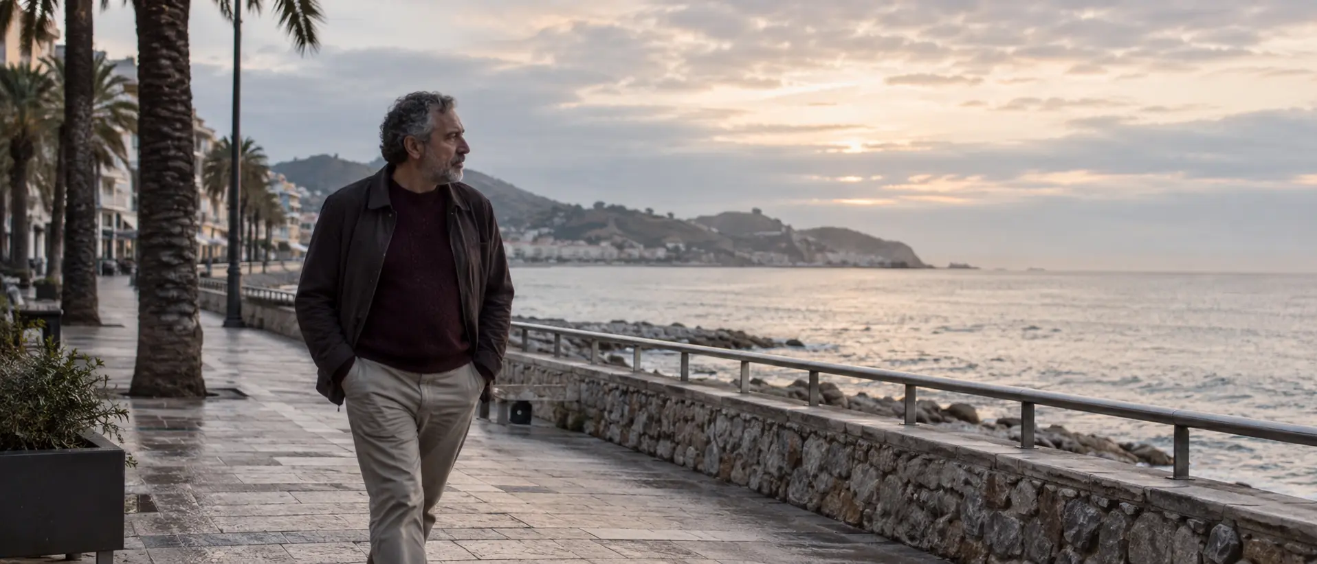 Hombre adulto paseando junto al mar al amanecer